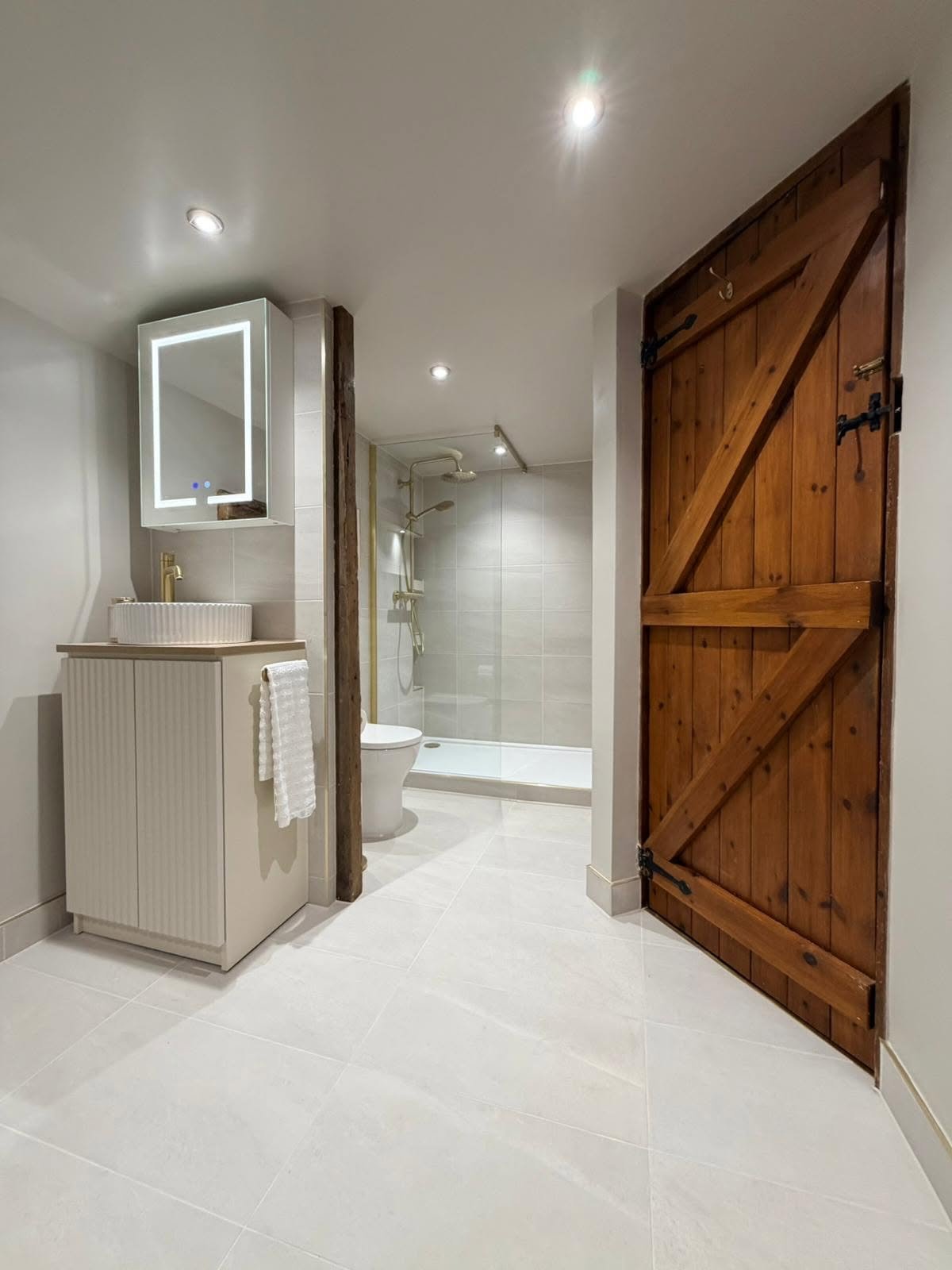 Bespoke bathroom storage and vanity design with timber details and walk-in shower