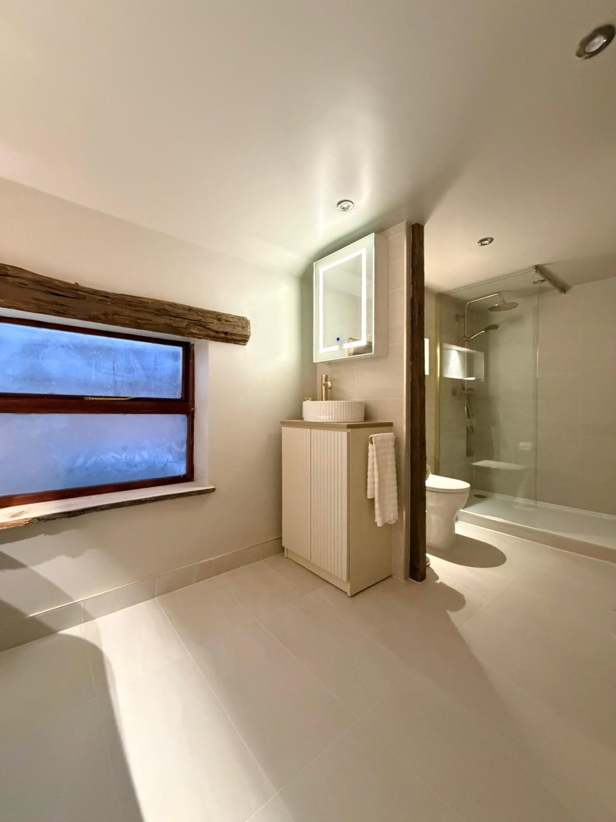 Bathroom vanity and basin installation with natural light and bespoke storage design