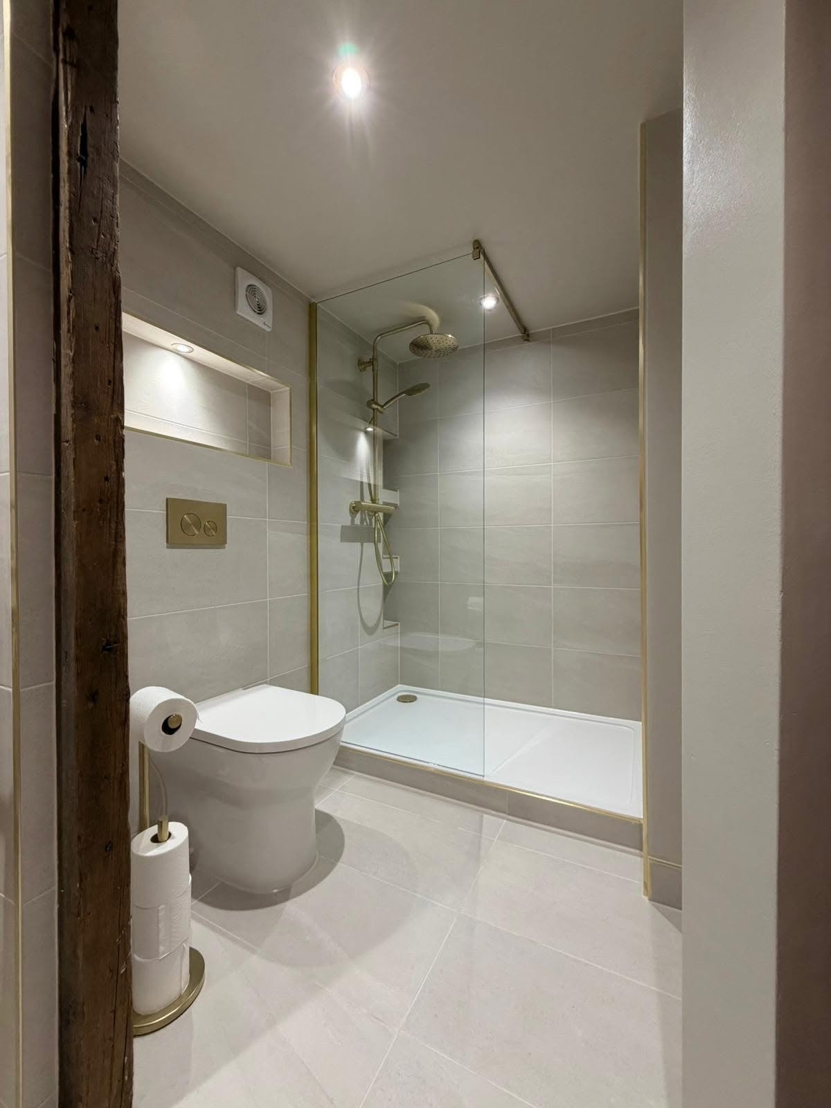 Complete bathroom installation in Derbyshire with walk-in shower and coordinated brass fittings